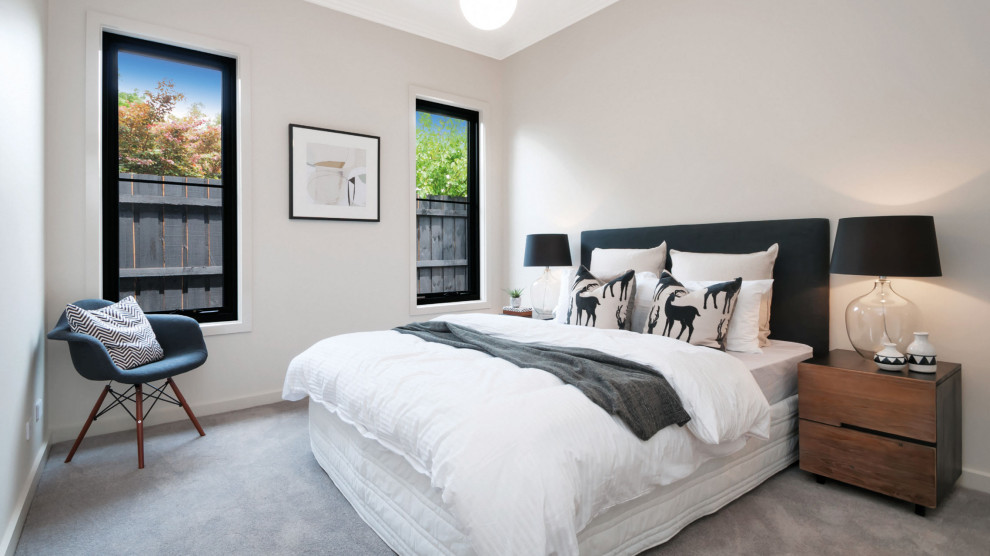 Foto di una camera da letto design con pareti grigie, moquette e pavimento grigio