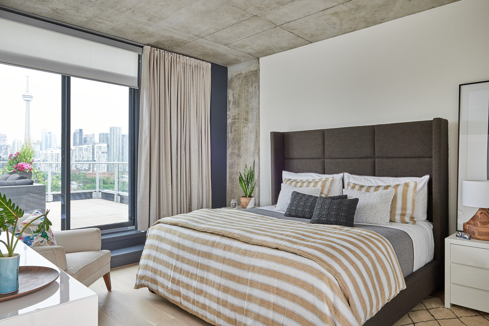 Medium sized modern master bedroom in Toronto with white walls, light hardwood flooring and white floors.