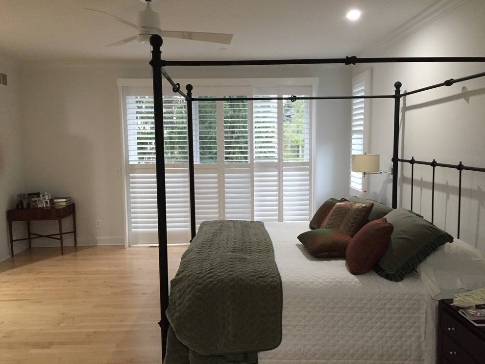 На фото: хозяйская спальня среднего размера в классическом стиле с серыми стенами, светлым паркетным полом и коричневым полом без камина с