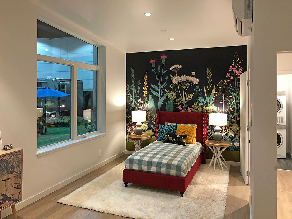Imagen de habitación de invitados actual de tamaño medio con paredes blancas, suelo de madera clara y suelo marrón