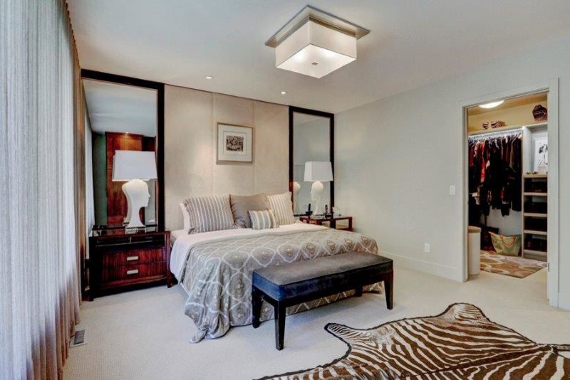 This is an example of a large contemporary master bedroom in Calgary with grey walls, carpet, a two-sided fireplace and a tiled fireplace surround.