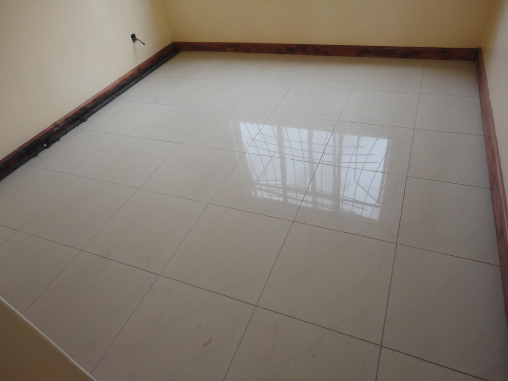 Cette image montre une chambre d'amis minimaliste de taille moyenne avec un mur beige, un sol en carrelage de céramique et aucune cheminée.
