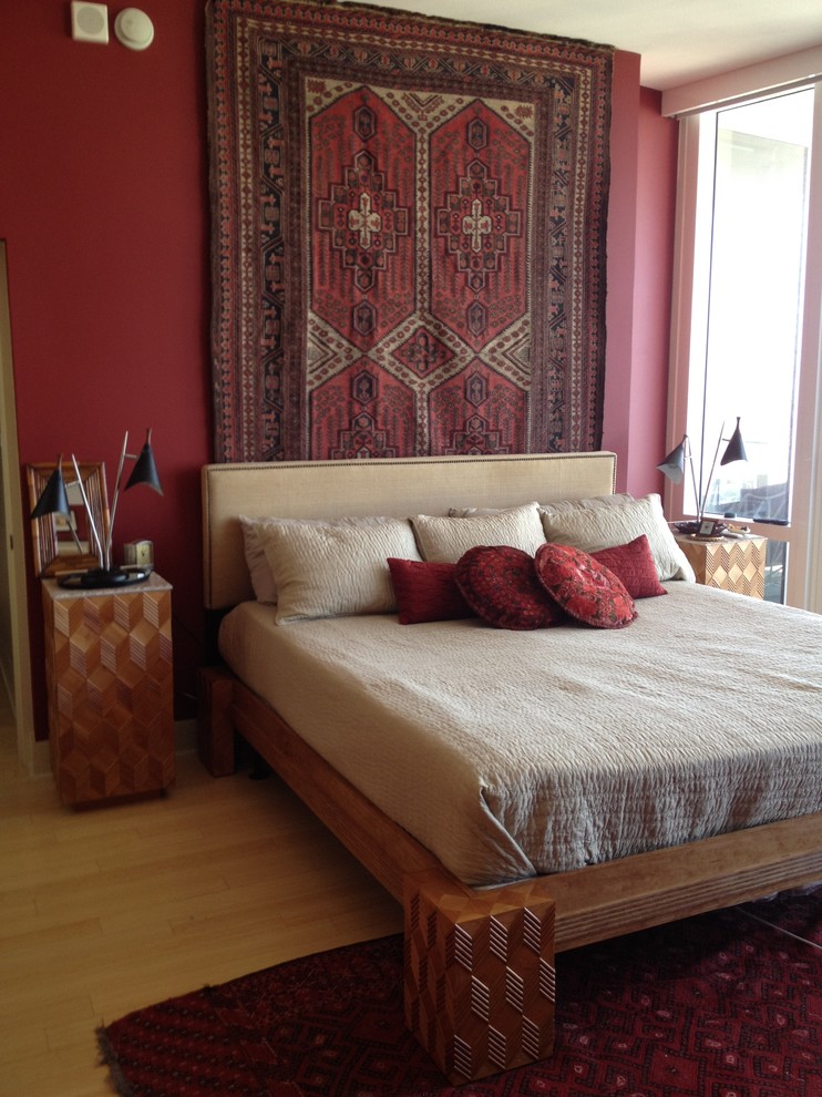 Immagine di una camera da letto boho chic di medie dimensioni con pareti rosse e parquet chiaro