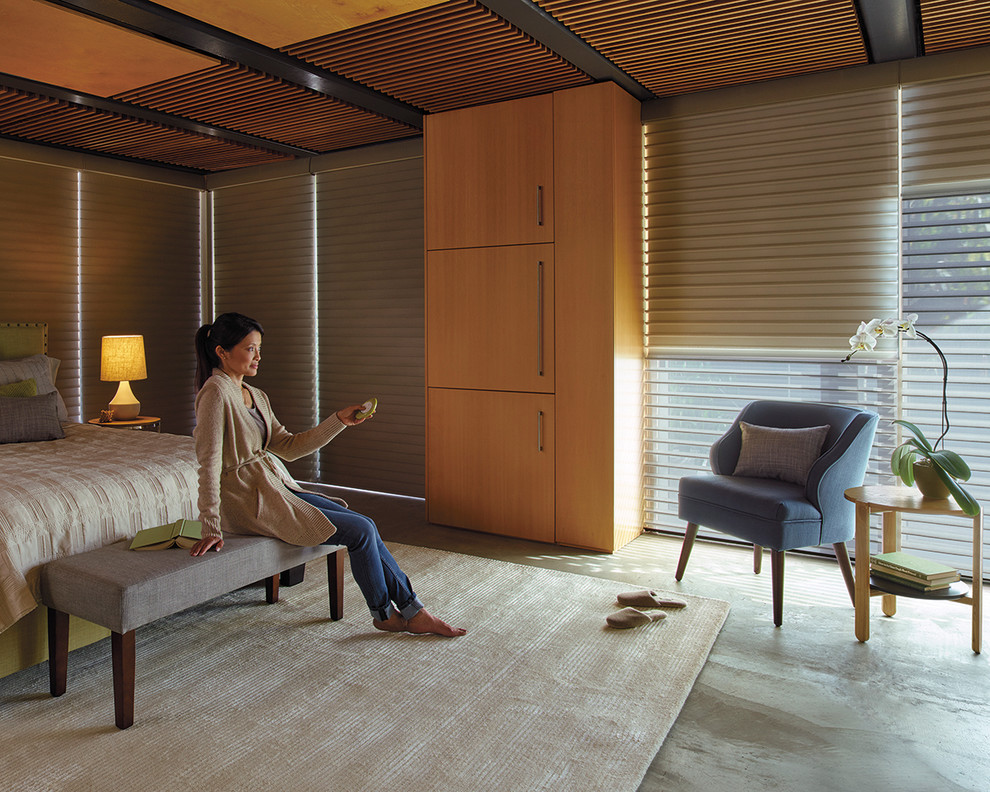 На фото: хозяйская спальня среднего размера в современном стиле с бетонным полом без камина с