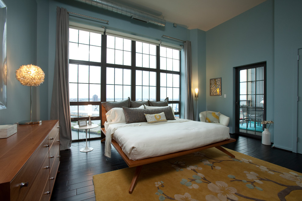 На фото: хозяйская спальня среднего размера в стиле модернизм с синими стенами и темным паркетным полом без камина с