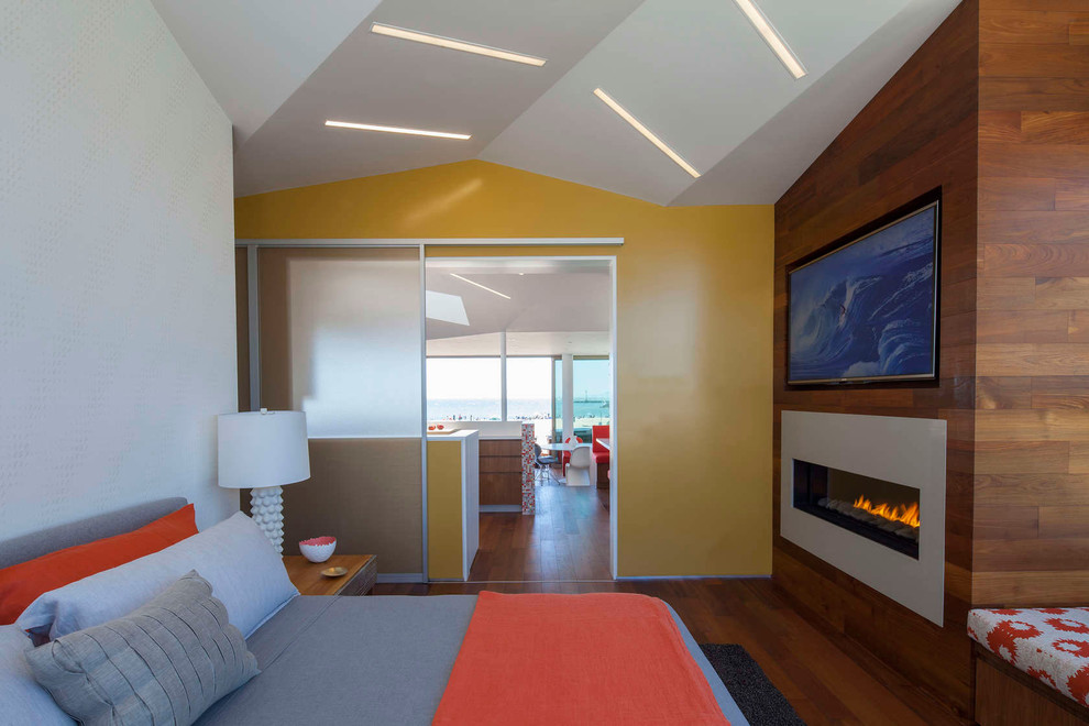 ロサンゼルスにある中くらいなコンテンポラリースタイルのおしゃれな客用寝室 (マルチカラーの壁、濃色無垢フローリング、横長型暖炉、金属の暖炉まわり、茶色い床、グレーとブラウン)