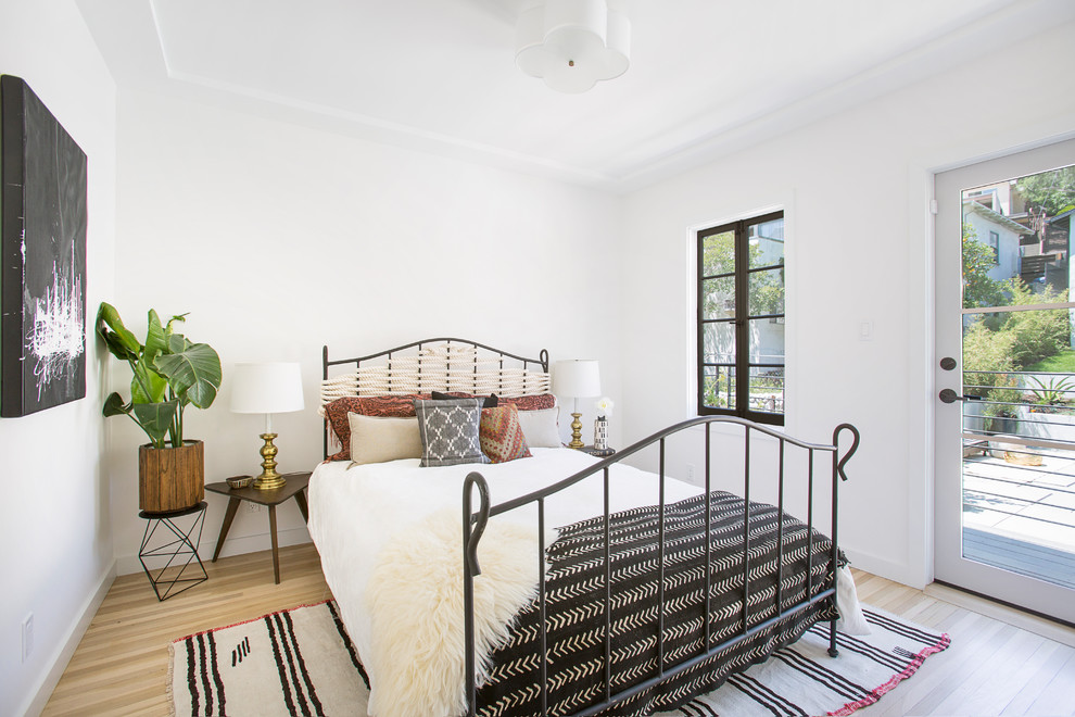 Modelo de habitación de invitados tradicional renovada de tamaño medio sin chimenea con paredes blancas, suelo de madera clara y suelo beige