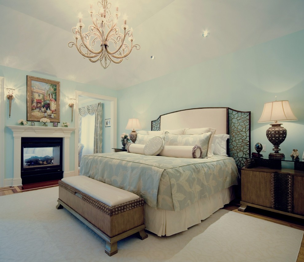 Источник вдохновения для домашнего уюта: большая хозяйская спальня в классическом стиле с светлым паркетным полом, двусторонним камином и фасадом камина из металла