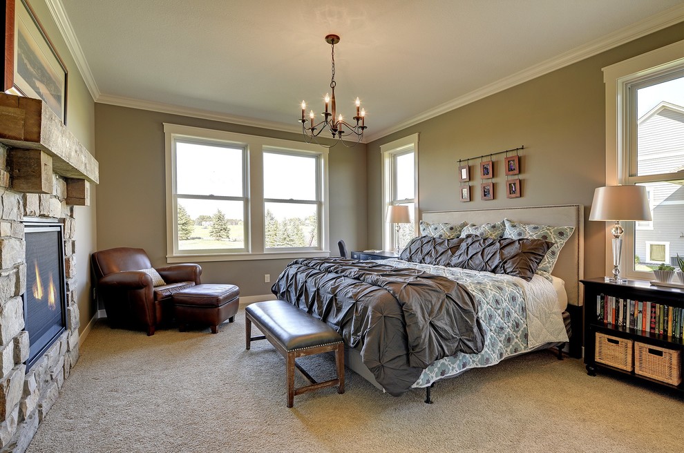 Modelo de dormitorio principal de estilo americano con paredes marrones, moqueta, chimenea de doble cara, marco de chimenea de piedra y suelo marrón