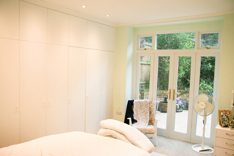 Imagen de dormitorio principal actual de tamaño medio con paredes blancas y moqueta