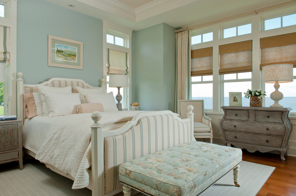 Imagen de dormitorio costero con paredes azules y suelo de madera en tonos medios