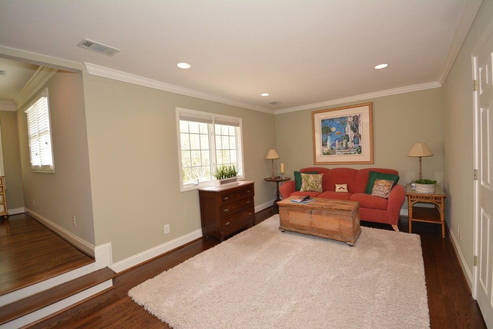 Cette image montre une petite chambre parentale traditionnelle avec un mur vert, un sol en bois brun et un sol marron.