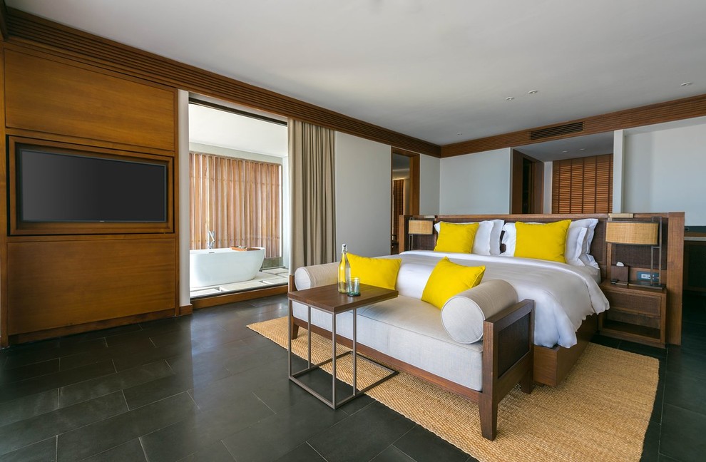 Imagen de dormitorio principal tropical sin chimenea con paredes blancas y suelo negro
