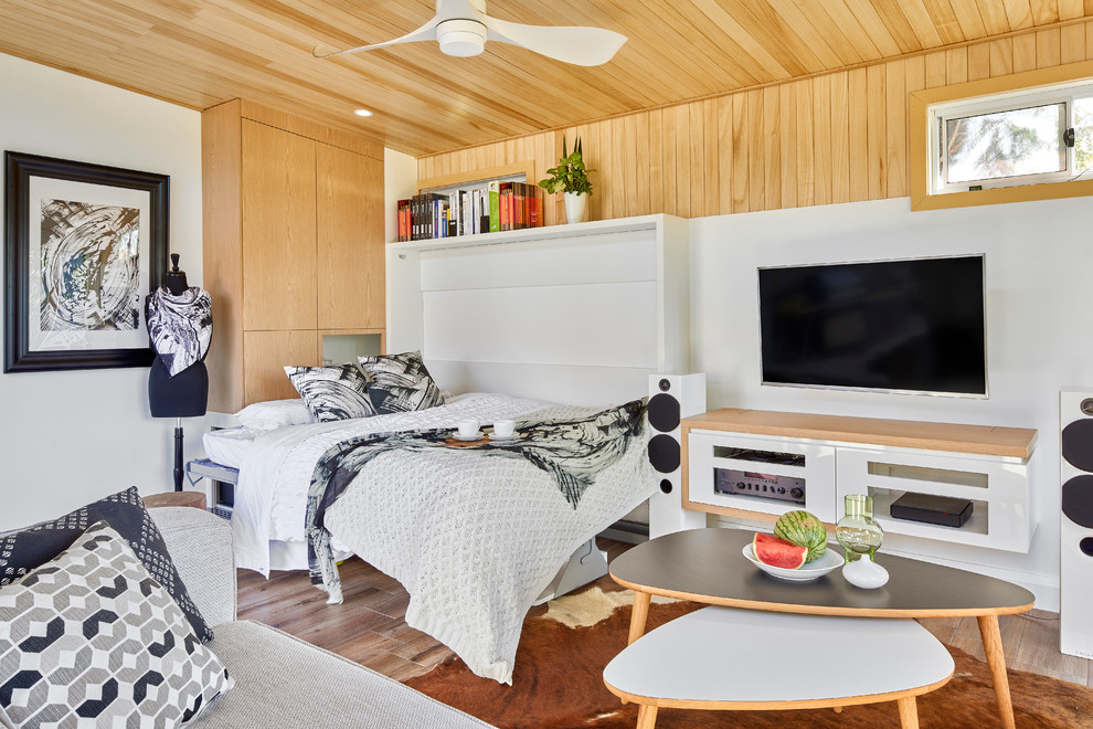 Inspiration för ett litet funkis sovrum, med vita väggar och mellanmörkt trägolv