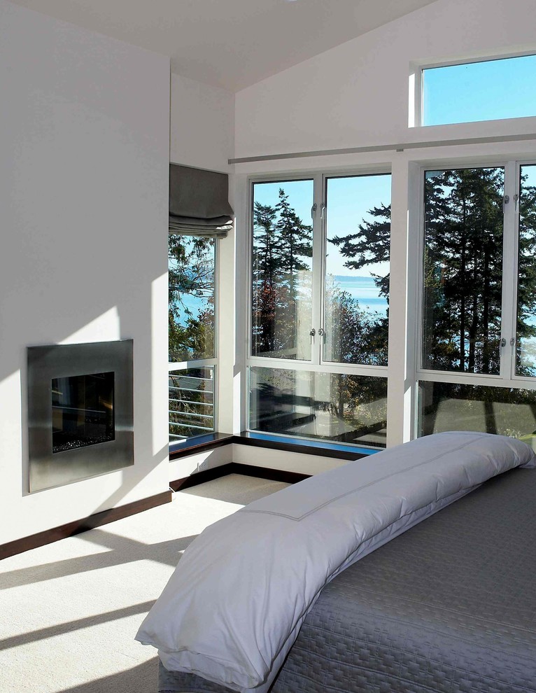 Medium sized modern master bedroom in Seattle with white walls, carpet, a standard fireplace, a metal fireplace surround and white floors.