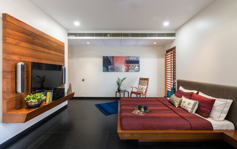 他の地域にあるコンテンポラリースタイルのおしゃれな主寝室 (白い壁、黒い床、コンクリートの床) のレイアウト