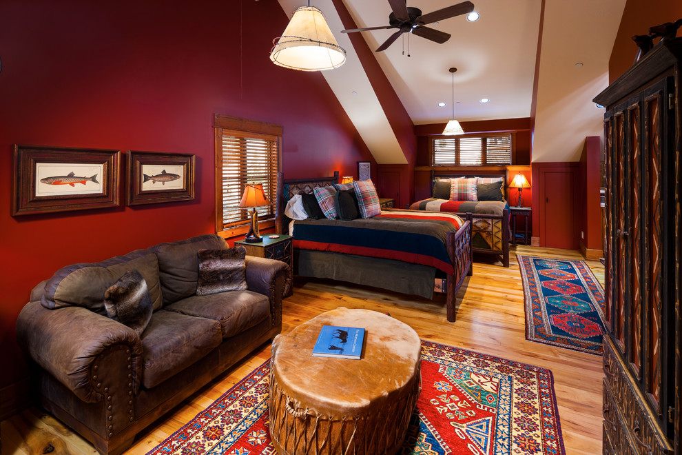 Large traditional guest bedroom in Other with red walls and medium hardwood flooring.