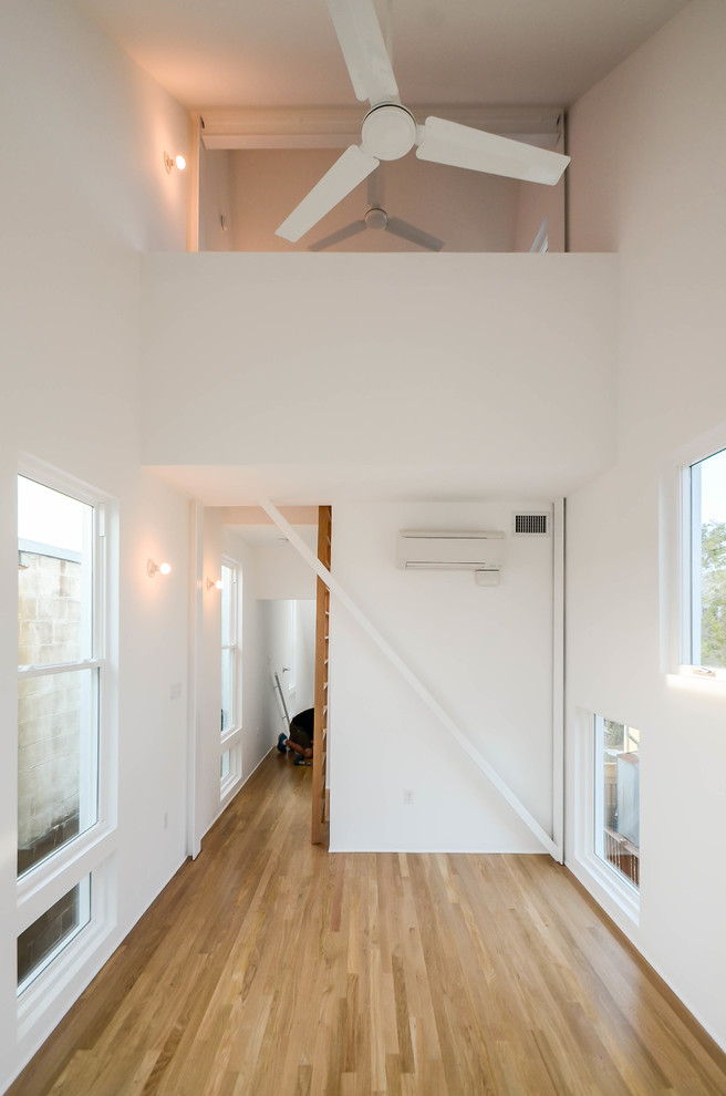 Inspiration för små moderna huvudsovrum, med vita väggar och ljust trägolv