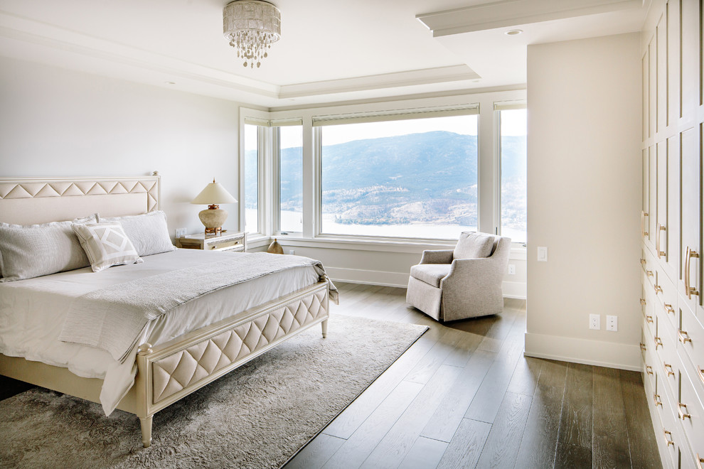 Klassisches Schlafzimmer mit beiger Wandfarbe, dunklem Holzboden und braunem Boden in Vancouver