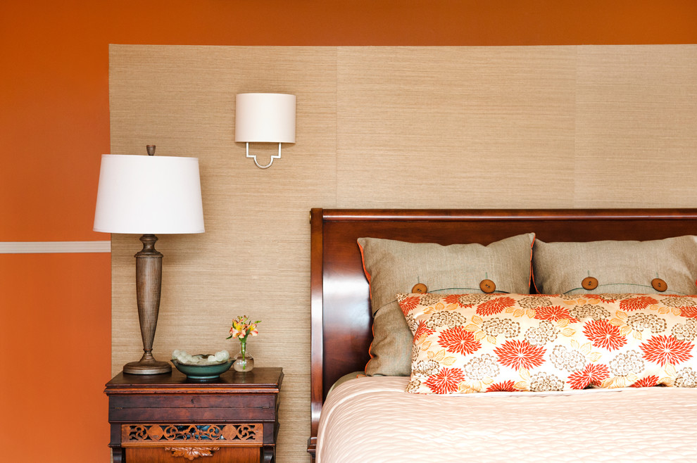 Inspiration pour une grande chambre parentale design avec un mur orange, un sol en bois brun et aucune cheminée.