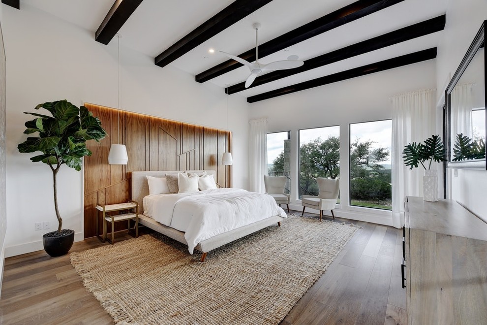 Inspiration för ett stort minimalistiskt huvudsovrum, med vita väggar, mellanmörkt trägolv och brunt golv