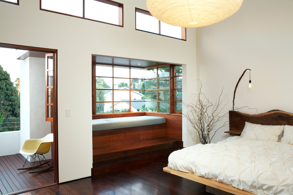 Photo of a contemporary bedroom in Los Angeles with white walls and dark hardwood flooring.