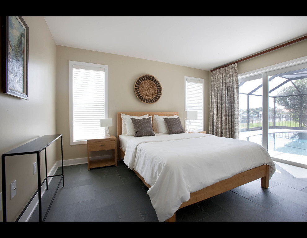 Imagen de habitación de invitados actual de tamaño medio sin chimenea con paredes beige y suelo de pizarra