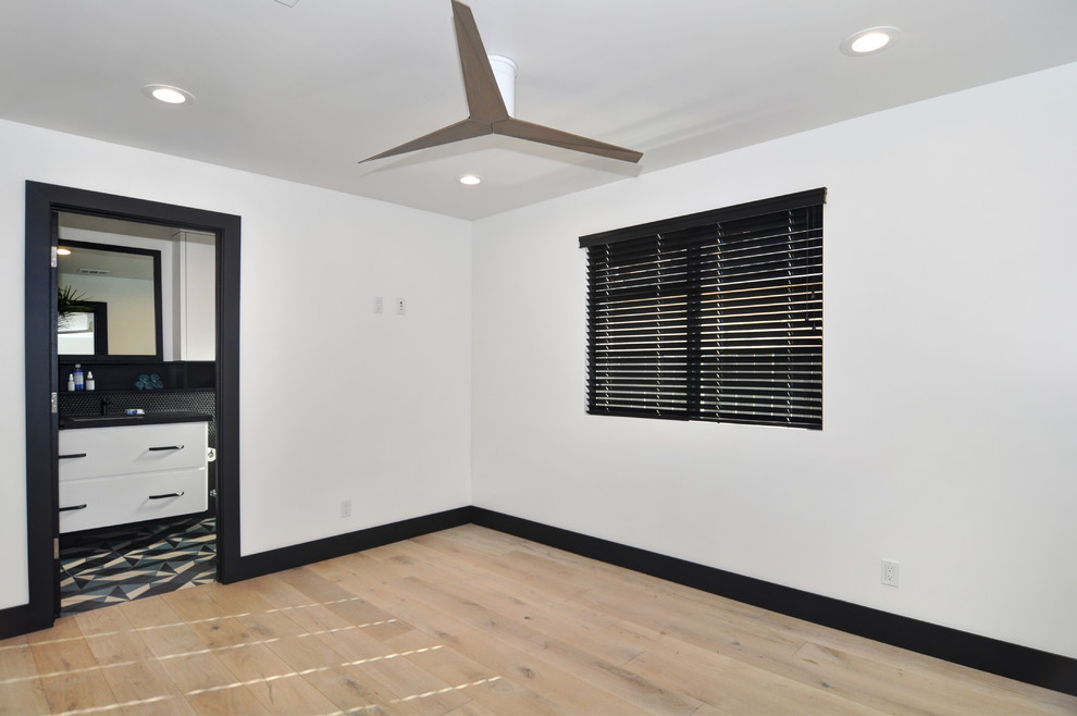 Modelo de habitación de invitados clásica renovada de tamaño medio sin chimenea con paredes blancas, suelo de madera clara y suelo beige