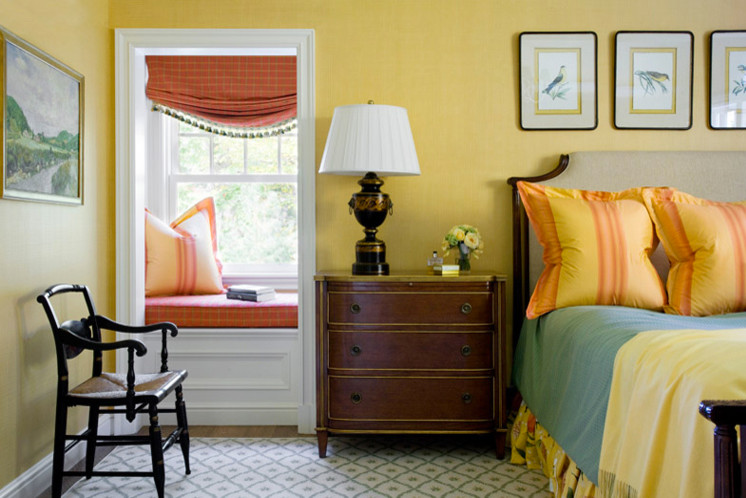 Exemple d'une grande chambre parentale chic avec un mur jaune, un sol en bois brun, aucune cheminée et un sol marron.
