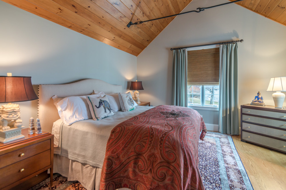 Ejemplo de dormitorio principal clásico renovado grande sin chimenea con paredes grises, suelo de madera clara y suelo marrón