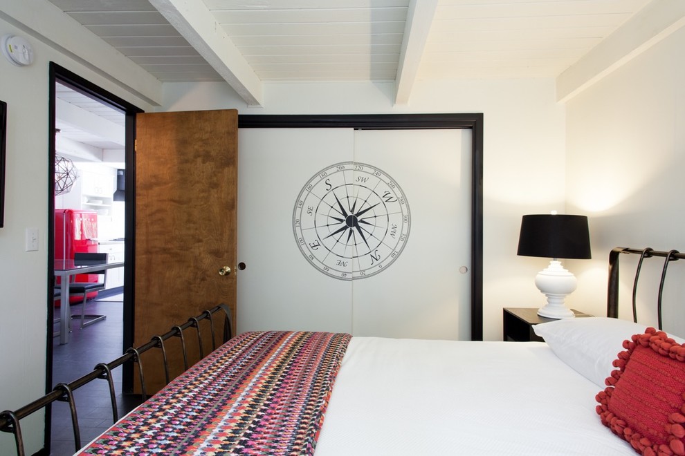 Inspiration för ett litet eklektiskt gästrum, med vita väggar, svart golv och laminatgolv