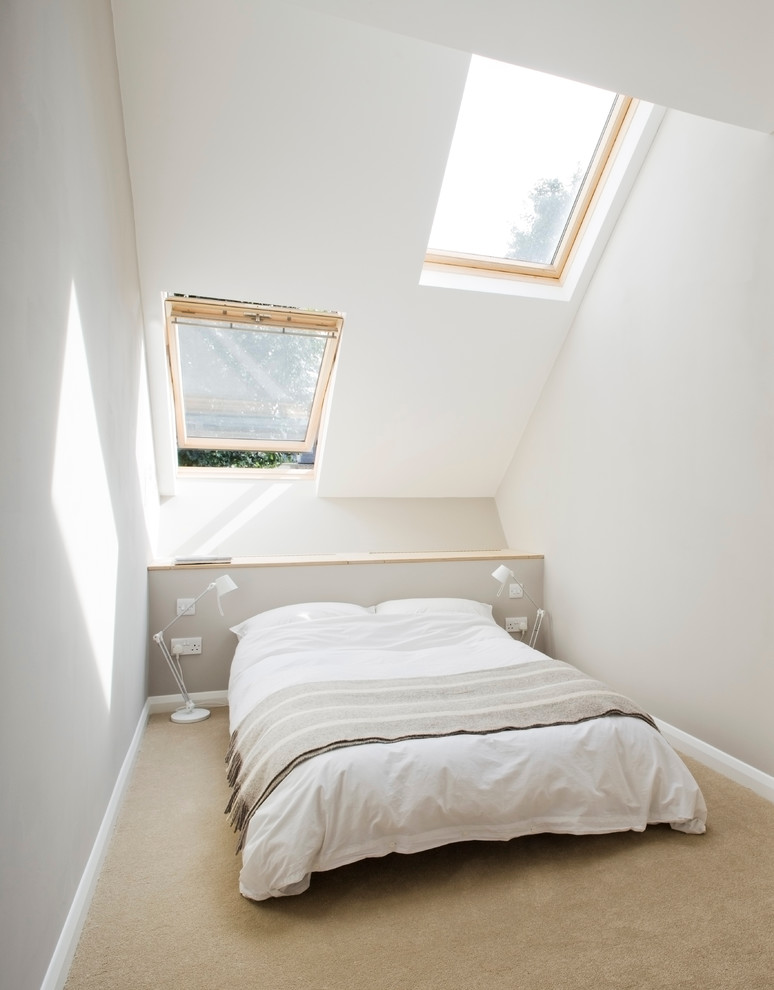 Photo of a small contemporary bedroom in London with white walls and carpet.