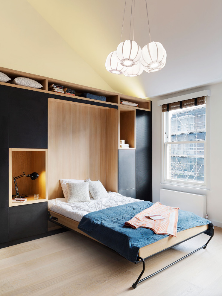 Cette image montre une chambre d'amis design de taille moyenne avec un mur blanc, parquet clair et un sol beige.