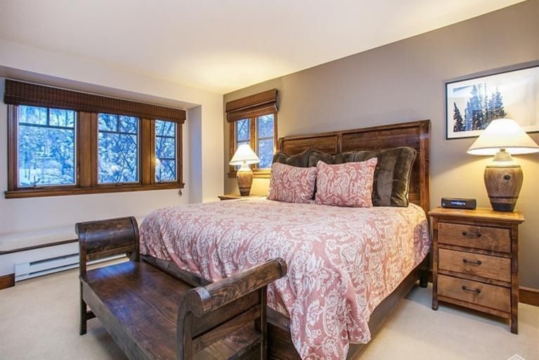 Diseño de dormitorio principal rural con paredes beige, moqueta y suelo beige