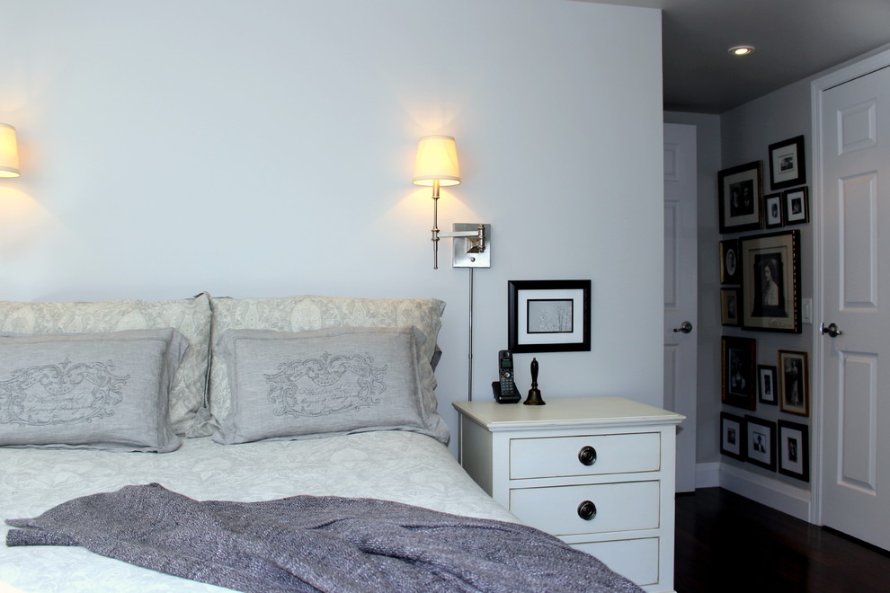 Modelo de dormitorio principal tradicional renovado pequeño con paredes grises y suelo de madera oscura
