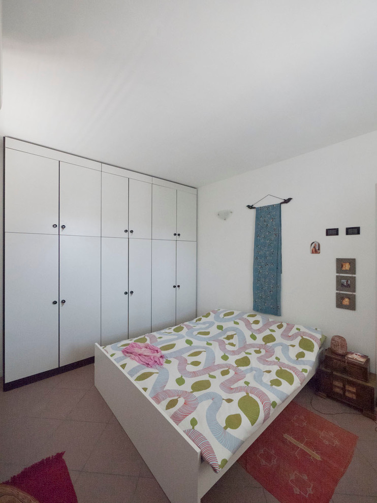 Imagen de dormitorio principal bohemio pequeño sin chimenea con paredes blancas y suelo de baldosas de cerámica