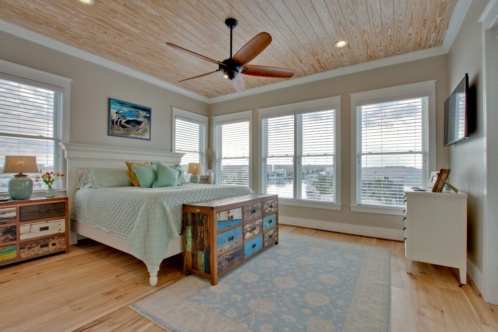 Imagen de dormitorio costero con paredes beige, suelo de madera clara y suelo beige