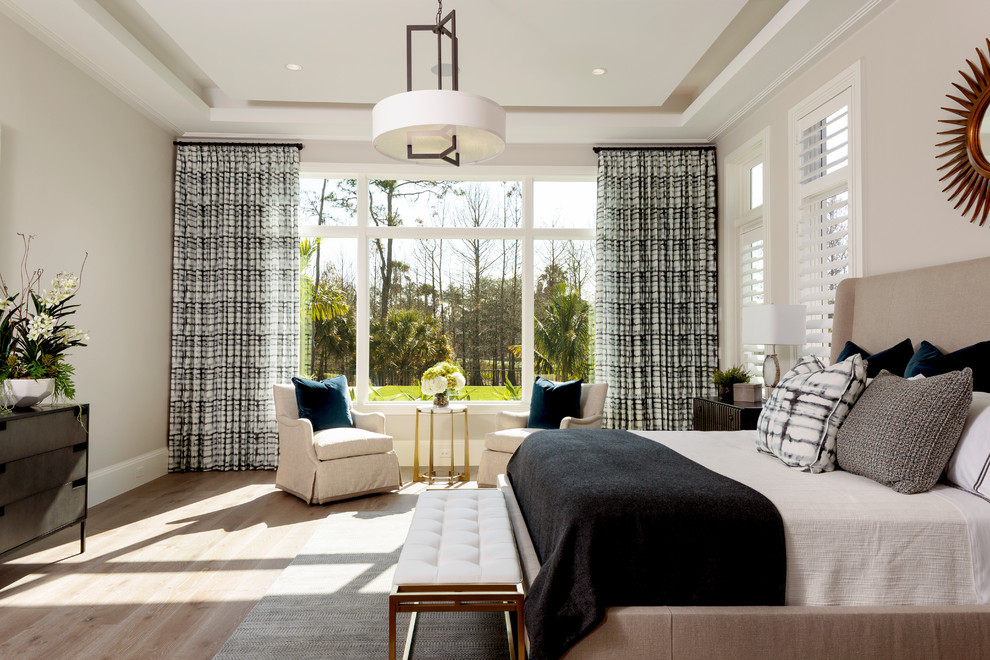 Inspiration for a large transitional master light wood floor and beige floor bedroom remodel in Miami with beige walls and no fireplace
