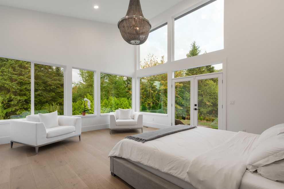 Modern master bedroom in Seattle with white walls and light hardwood flooring.