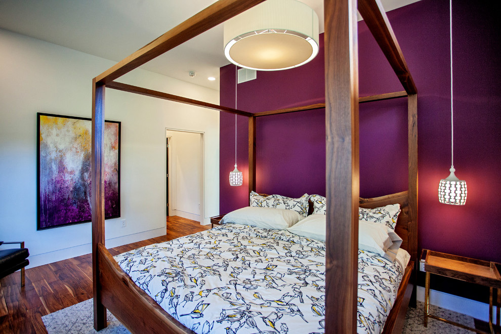 На фото: хозяйская спальня среднего размера в стиле модернизм с фиолетовыми стенами и паркетным полом среднего тона с