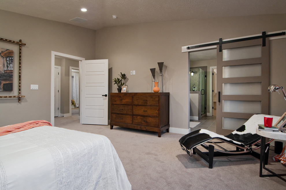 This is an example of a contemporary master bedroom in Salt Lake City with beige walls, carpet and no fireplace.