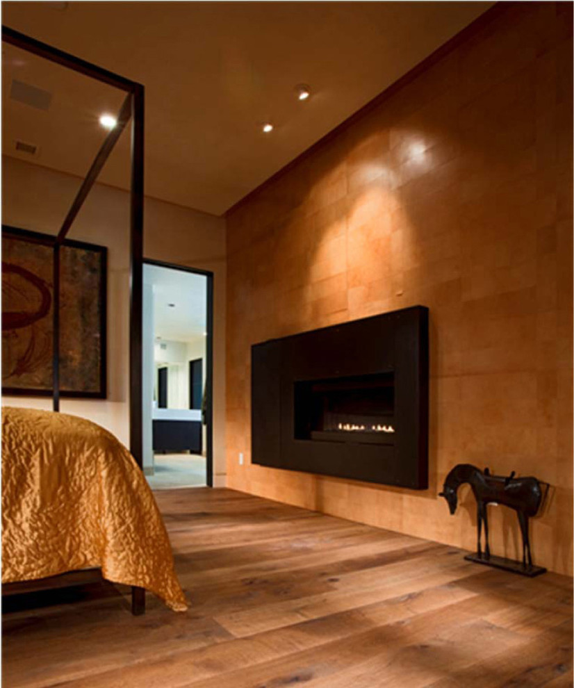 Cette image montre une grande chambre parentale design avec un mur beige, parquet clair, une cheminée ribbon et un manteau de cheminée en métal.