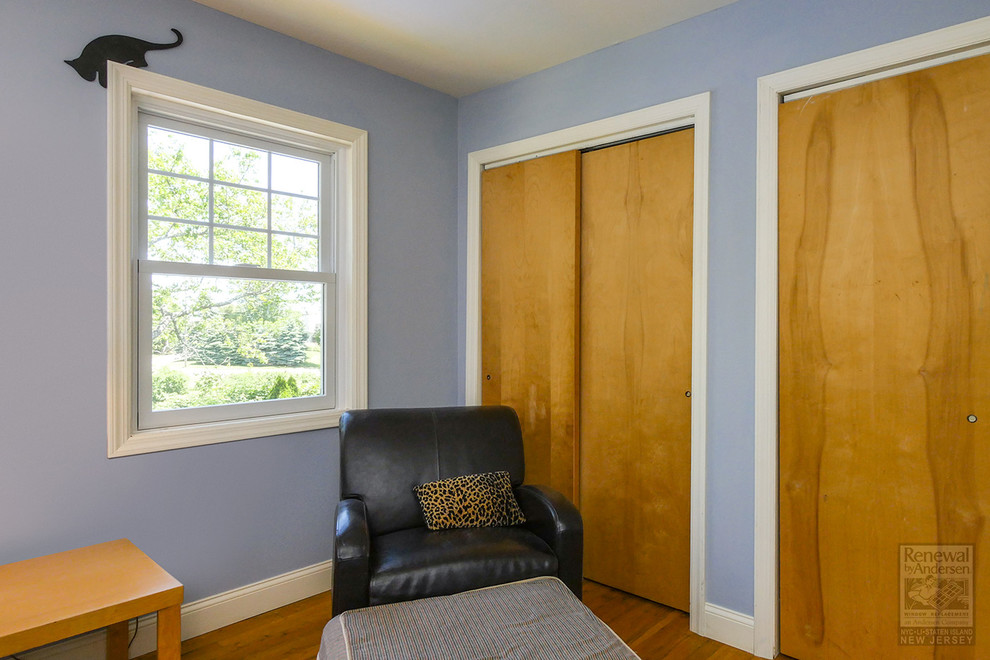 Diseño de habitación de invitados de tamaño medio con paredes azules, suelo de madera en tonos medios y suelo marrón