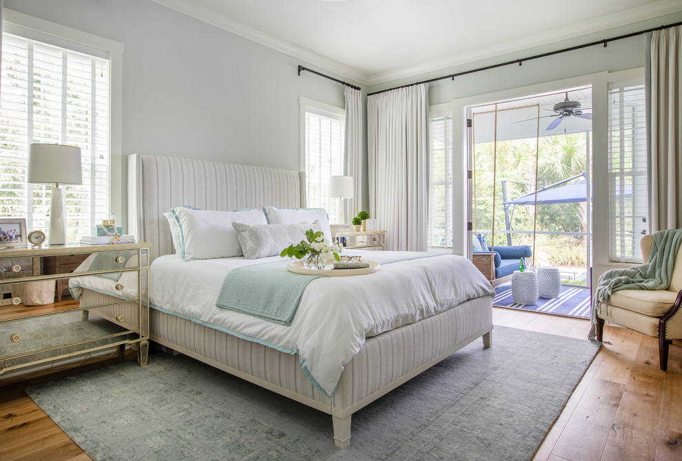 Foto di una camera da letto costiera con pareti blu, pavimento in legno massello medio e pavimento marrone