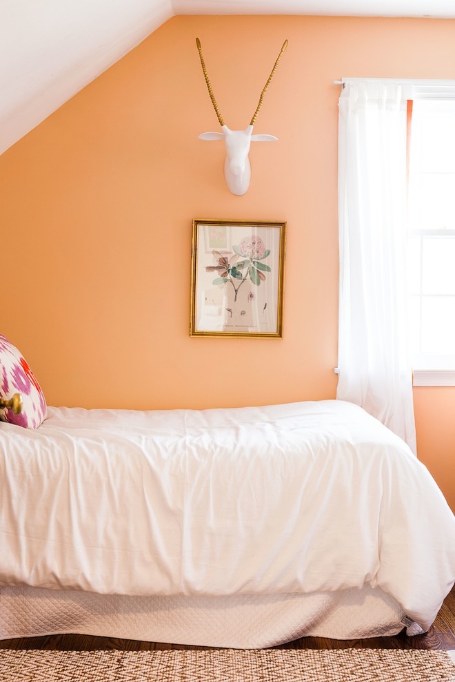 Cette photo montre une chambre chic avec un mur orange et parquet foncé.