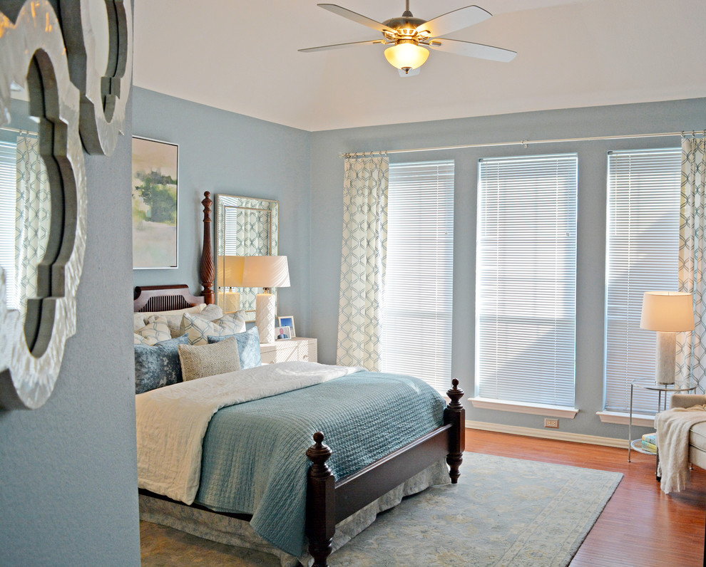 Idée de décoration pour une petite chambre parentale design avec un mur bleu, sol en stratifié et un sol marron.