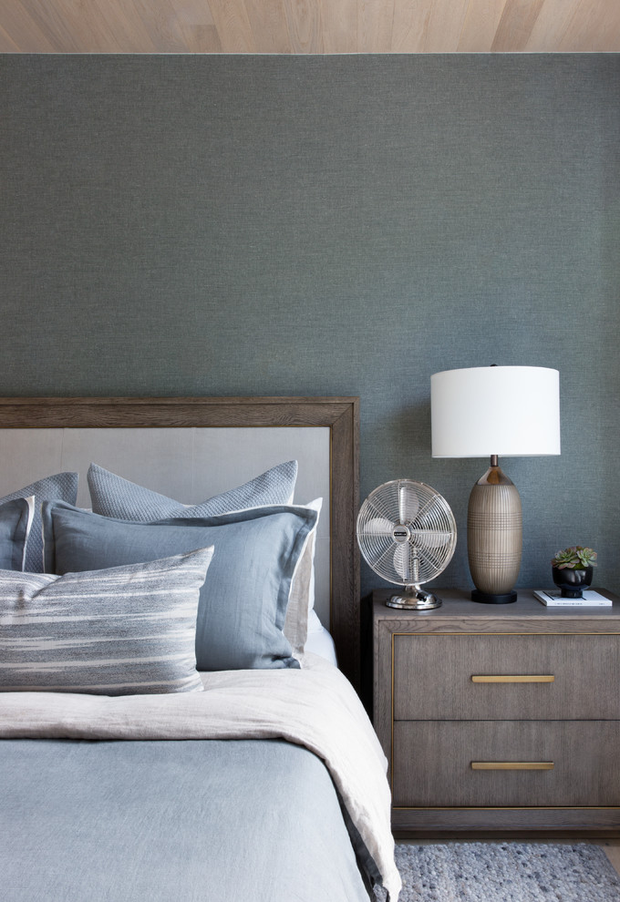 Idée de décoration pour une chambre parentale minimaliste de taille moyenne avec un mur gris, parquet clair et un sol marron.
