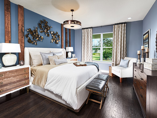 A serene bedroom with dark gray-blue blue walls and a pristine white bed, creating a peaceful ambiance.