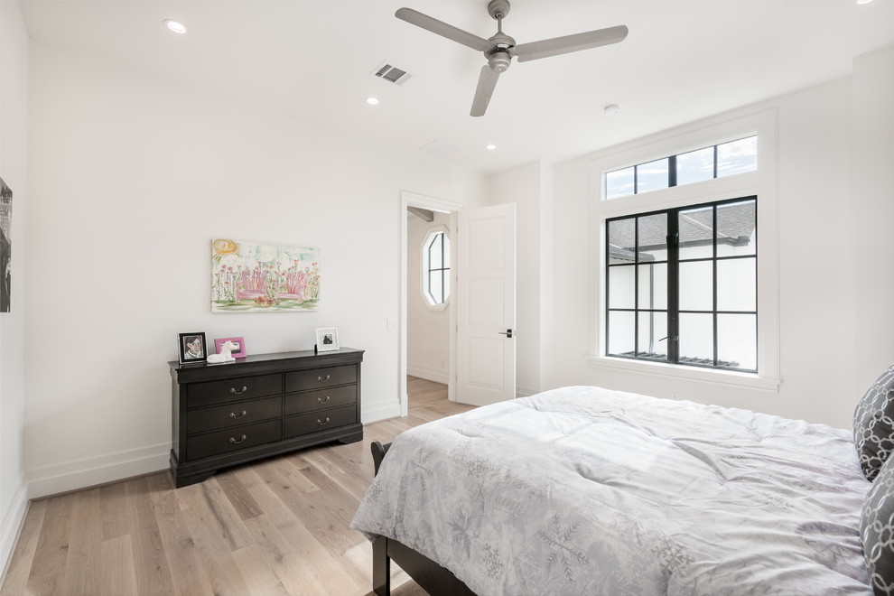 Mid-sized transitional guest light wood floor and beige floor bedroom photo in Houston with white walls and no fireplace