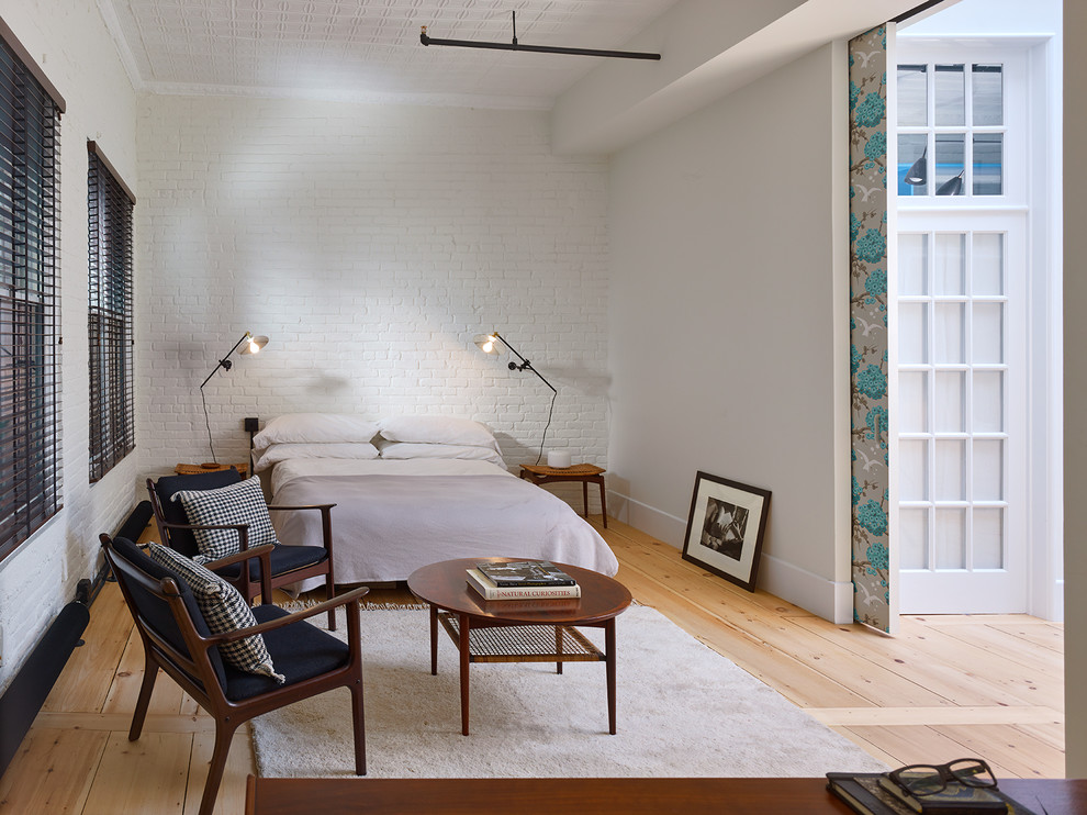 Industrial Hauptschlafzimmer ohne Kamin mit weißer Wandfarbe und hellem Holzboden in New York